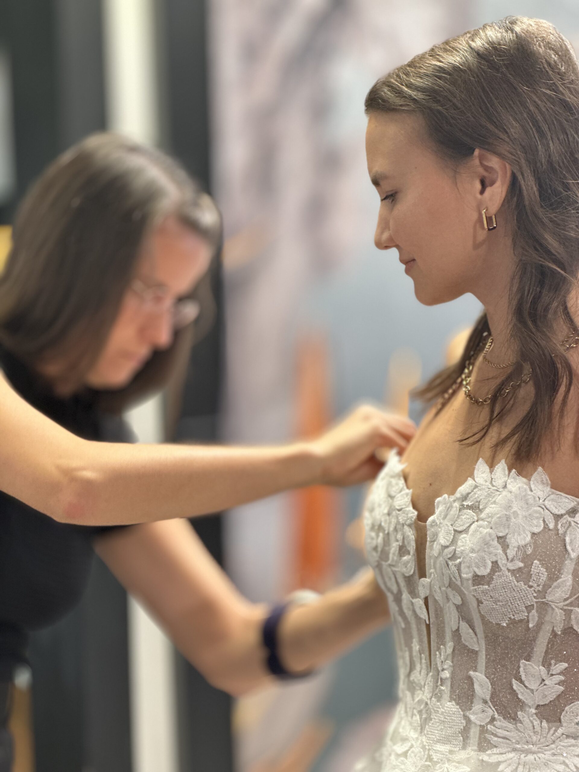 Schneiderin passt ein Brautkleid bei der finalen Anprobe an