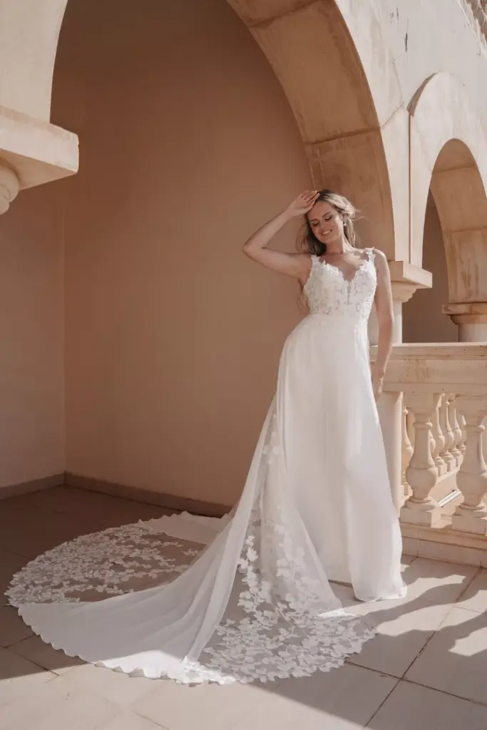 Brautkleid mit Spitzenoberteil, fließendem Rock und Spitzenbesatz an der Schleppe