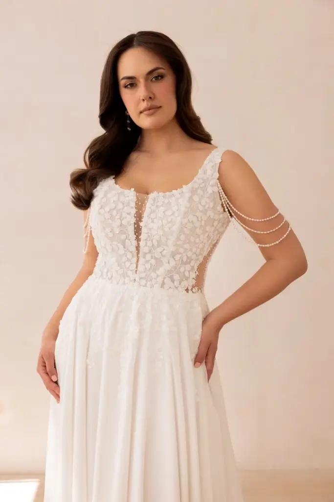 Detail eines Brautkleids mit Spitzenoberteil und Perlenketten an den Schultern