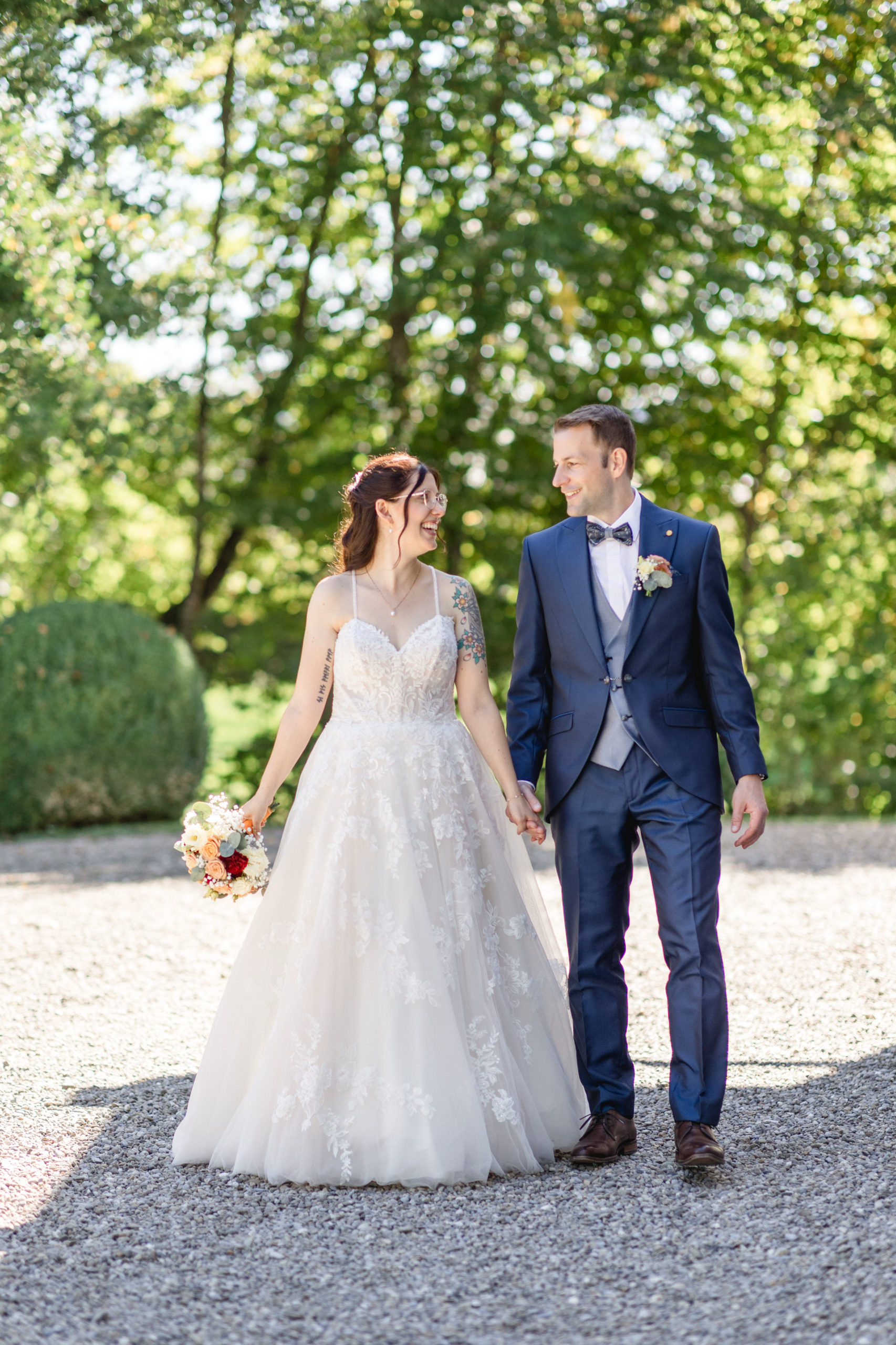 Sabrina im Brautkleid und Michael im blauen Hochzeitsanzug im Schlosspark